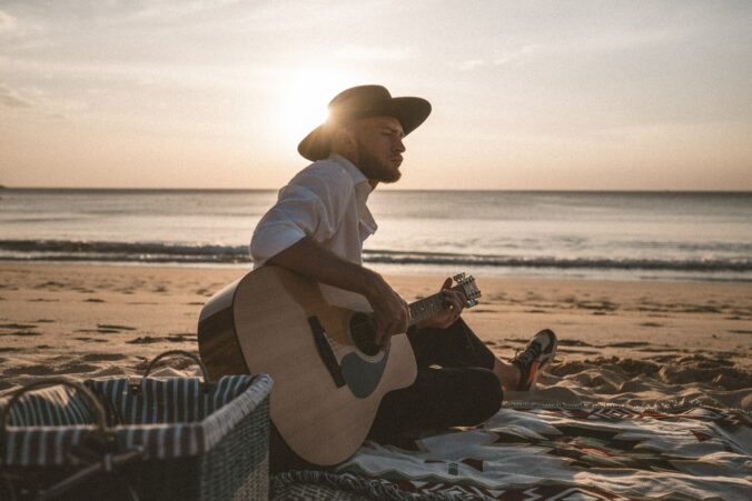 Man playing guitar on a beach